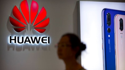 A shopper walks past a Huawei store in Beijing, July 4, 2018.