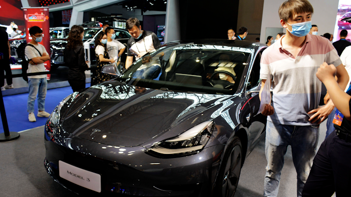 Visitors look at a Tesla Model 3 vehicle on display at an auto show in southwestern China's Chongqing Municipality, June 13, 2020.