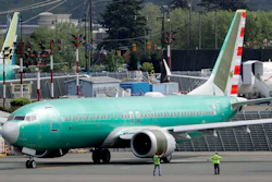 Workers stand near a Boeing 737 Max 8 jetliner being built for American Airlines.