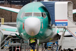 A worker looks up underneath a Boeing 737 Max jet in Renton, Wash., Dec. 16, 2019.