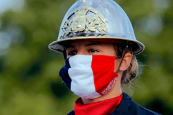 A firefighter wears a face mask with the colors of the French flag.