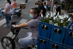 A delivery man transports beer on the streets of Beijing.