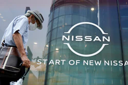 A man walks by new logo of Nissan seen at the automaker's showroom in Tokyo.