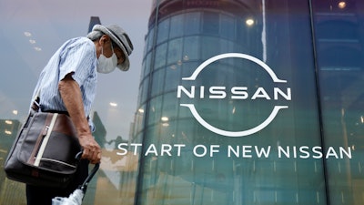A man walks by new logo of Nissan seen at the automaker's showroom in Tokyo.