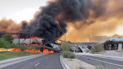 Smoke fills the sky at the scene of a train derailment.