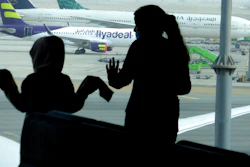 Passengers watch aircraft on the tarmac as they wait for their flight at the King Abdulaziz International Airport in Jiddah, Saudi Arabia, Tuesday, July 28, 2020. Few flights are scheduled for international departures only but the authorities have eased domestic travel restrictions since June.