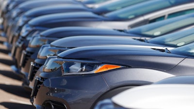 In this file photo dated June 7, 2020, a long row of unsold cars at a Honda dealership in Highlands Ranch, Colo. The coronavirus pandemic is causing drivers to keep their cars and trucks longer. The IHS Markit consulting firm says the pandemic has caused consumers to put the brakes on spending and hold onto their current vehicles for a longer period.