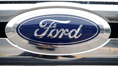 In this Oct. 20, 2019 file photograph, the company logo shines off the grille of an unsold 2019 F-250 pickup truck at a Ford dealership in Littleton, Colo. Ford Motor Co. reports quarterly financial results after the market close, Thursday, July 30 2020.