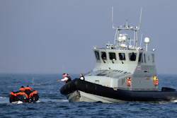 A Border Force vessel assist a group of people thought to be migrants on board from their inflatable dinghy in the Channel.