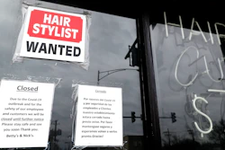 A barber shop shows closed and hiring signs in Chicago, April 30, 2020.