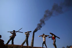 In this June 4, 2011 file photo, Indian laborers carry firewood, as smoke rises from a bricks factory on the outskirts of Jammu, India. India should commit to carbon neutrality by ending fossil fuel subsidies and investing in clean solar power as it mobilizes trillion of dollars to recover from the coronavirus pandemic, the U.N. Secretary-General António Guterres said Friday, Aug. 28, 2020.