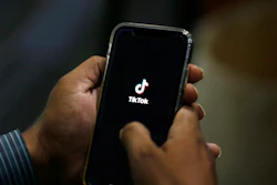 In this July 21, 2020 file photo, a man opens social media app 'TikTok' on his cell phone, in Islamabad, Pakistan. Walmart said Thursday, Aug. 27, that it's interested in teaming up with Microsoft to buy the U.S. business of TikTok, the popular Chinese video app.