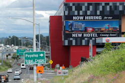 In this July 9, 2020, file photo, a large video display reads 'Now hiring for our new hotel coming soon!,' at the new Emerald Queen Casino, which is open, and owned by the Puyallup Tribe of Indians, in Tacoma, Wash. The United States added 1.8 million jobs in July, a pullback from the gains of May and June and evidence that the resurgent coronavirus has weakened hiring and the economic rebound.