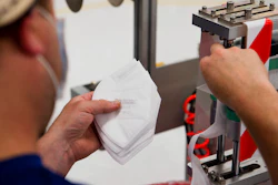 A worker handles filter material for face masks in Seattle.