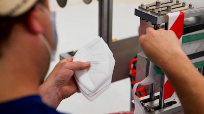 A worker handles filter material for face masks in Seattle.