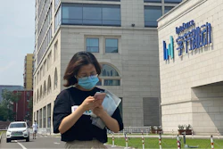 A woman uses her phone as she passes by the ByteDance headquarters in Beijing, China.