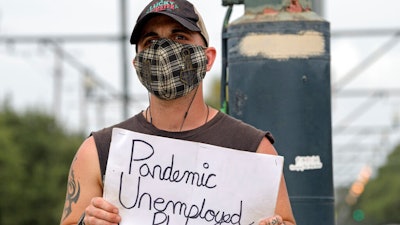 Sean Harris holds a sign asking for help.