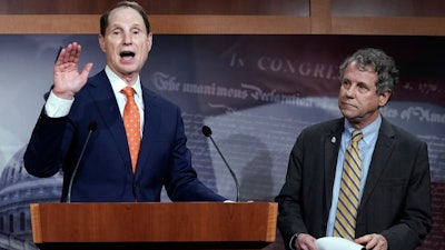 In this Jan. 15, 2020 photo, Senate Finance Committee ranking member Ron Wyden, D-Ore., speaks during a news conference at the Capitol in Washington, about a U.S. China trade agreement, accompanied by Sen. Sherrod Brown, D-Ohio, right.