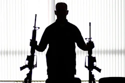 ATF agent poses with homemade rifles, or 'ghost guns.'