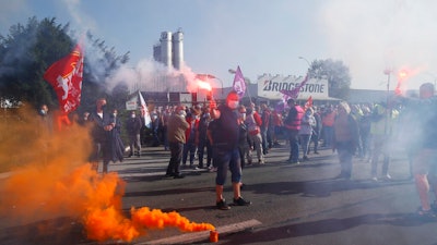 Bridgestone employees fire flares outside the tire factory of Bethune, northern France, Thursday, Sept.17, 2020. Workers protest over the Japan-based company's decision to close the plant and lay off all its nearly 900 workers. Bridgestone argues the factory is no longer competitive globally, but unions and French politicians accused the company of using the virus-driven economic crisis as a pretext for the closure and not investing in modernizing the plant instead.