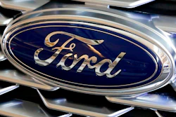 This Feb. 15, 2018, file photo shows a Ford logo on the grill of a 2018 Ford Explorer on display at the Pittsburgh Auto Show. Ford Motor Co. will offer early retirement incentives with hopes of cutting its U.S. white-collar workforce by 1,400 more positions. President for the Americas Kumar Galhotra told employees about the offers Wednesday, Sept. 2, 2020.