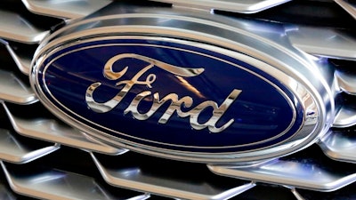 This Feb. 15, 2018, file photo shows a Ford logo on the grill of a 2018 Ford Explorer on display at the Pittsburgh Auto Show. Ford Motor Co. will offer early retirement incentives with hopes of cutting its U.S. white-collar workforce by 1,400 more positions. President for the Americas Kumar Galhotra told employees about the offers Wednesday, Sept. 2, 2020.