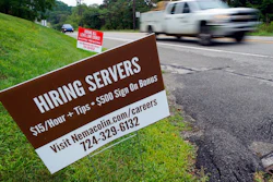 In this Wednesday, Sept. 2, 2020, file photo help wanted signs for servers and cooks at Nemacolin Woodlands Resort and Spa are displayed along route 40 at the entrance to the resort in Farmington, Pa. U.S. employers advertised more jobs but hired fewer workers in July, sending mixed signals about a job market in the wake of the coronavirus outbreak. The Labor Department said Wednesday, Sept. 9, 2020, that the number of U.S. job postings on the last day of July rose to 6.6 million from 6 million at the end of June.