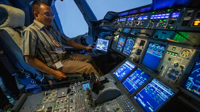 A customer sits in an Airbus A380 flight simulator for a flying experience.