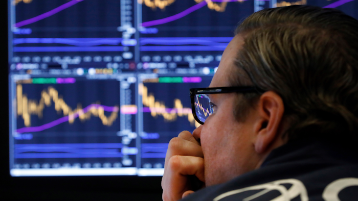 In this Jan. 28, 2020 photo, specialist Gregg Maloney watches the screens at his post on the floor of the New York Stock Exchange.