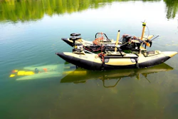 A yellow underwater robot finds its way to a mobile docking station to recharge and upload data before continuing a task.
