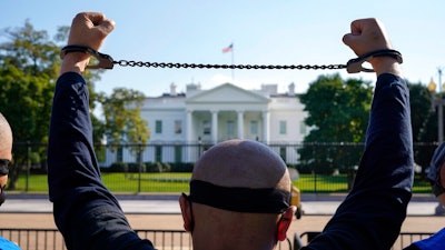 A member of the Uyghur American Association rallies in front of the White House, Thursday, Oct. 1, 2020, after marching from Capitol Hill in Washington, in support of the Uyghur Forced Labor Prevention Act which has passed the House and now will go on to the Senate. The bill prohibits some imports from Xinjiang and imposes sanctions for human rights violations.