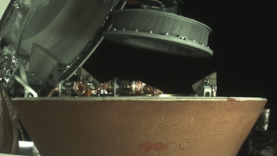 In this undated image provided by NASA, a sample container hovers over a capsule on the Osiris-Rex spacecraft near the asteroid Bennu.