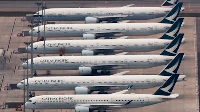 In this March 6, 2020, file photo, Cathay Pacific Airways aircrafts line up on the tarmac at the Hong Kong International Airport. Hong Kong airline Cathay Pacific Airways on Wednesday, Oct. 21, 2020, said it would cut 8,500 jobs and shut down its regional airline unit in a corporate restructuring, as it grapples with the plunge in air travel due to the pandemic.