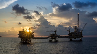 A silhouette of oil and gas production platforms in the South China Sea.