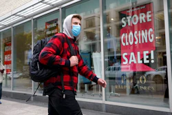 A passer-by walks past a store closing sign, right, in the window of a department store, Tuesday, Oct. 27, 2020, in Boston. Americans may feel whiplashed by a report Thursday, Oct. 29, on the economy's growth this summer, when an explosive rebound followed an epic collapse. The government will likely estimate that the economy grew faster on an annualized basis last quarter than in any such period since record-keeping began in 1947.