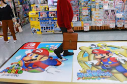 A shopper passes by an ad for Super Mario of Nintendo at an electronics store in Tokyo.