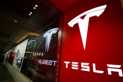 A sign bearing the company logo stands outside a Tesla store in Cherry Creek Mall in Denver.