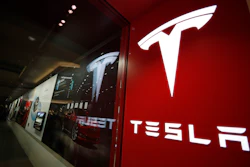 In this Feb. 9, 2019, file photo, a sign bearing the company logo stands outside a Tesla store in Cherry Creek Mall in Denver. U.S. safety regulators are continuing their investigation into complaints that Tesla’s giant touch screens can fail and cause the cars to lose the rear camera display and other functions. A preliminary investigation was opened in June 2020 covering 63,000 Model S vehicles.