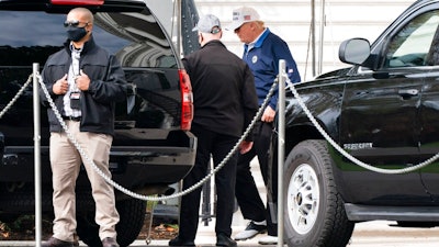 President Donald Trump, right, walks to the motorcade, Sunday, Nov. 22, 2020, as he departs the White House in Washington.