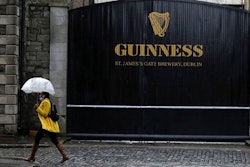 A woman passes the Guinness brewery in Dublin's city centre Wednesday Nov. 11, 2020. Irish brewer Guinness announced Wednesday it is recalling cans of its recently launched non-alcoholic stout in Britain, as a precautionary measure over contamination concerns.