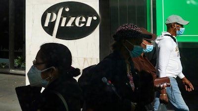 In this Nov. 9, 2020, file photo, pedestrians walk past Pfizer world headquarters in New York. Pfizer announced Wednesday, Nov. 18, 2020, more results in its ongoing coronavirus vaccine study that suggest the shots are 95% effective a month after the first dose.