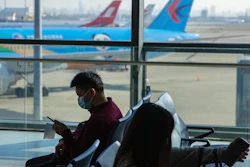Travelers sit at a boarding gate at Shanghai Hongqiao International Airport in Shanghai, Nov. 6, 2020.
