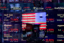 A United States flag reflected in the window of the Nasdaq studio, Times Square, New York, March 16, 2020.