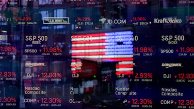 A United States flag reflected in the window of the Nasdaq studio, Times Square, New York, March 16, 2020.