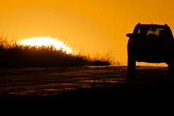 A motorist drives into the sunrise in Kansas City, Mo., Oct. 1, 2020.