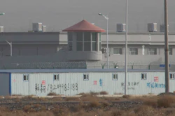 A guard tower and barbed wire fences are seen around a facility in the Kunshan Industrial Park in Artux in western China's Xinjiang region.