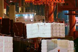 In this Sept. 25, 2020, file photo, a worker looks at goods being loaded onto a container ship at a dockyard in Qingdao in east China's Shandong province. China’s politically sensitive trade surplus with the U.S. soared to a record $75.4 billion November as exports surged 21.1% over a year earlier, propelled by strong demand from American consumers, customs data showed Monday, Dec. 7, 2020.