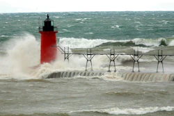 In this April 6, 2017 file photo, strong winds send huge waves at the Lake Michigan shoreline at South Haven Michigan. A decade-old program that has pumped $2.7 billion into healing long-term injuries to the Great Lakes environment has received authorization from Congress to continue another five years. The U.S. Senate voted unanimously Sunday, Dec. 20, 2020, to extend the Great Lakes Restoration Initiative, which the House did earlier this year.