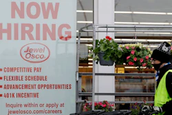 A man pushes carts as a hiring sign shows at a Jewel Osco grocery store in Deerfield, Ill., Thursday, April 23, 2020. Friday, Dec. 4, monthly U.S. jobs report will help answer a key question hanging over the economy: Just how much damage is being caused by the resurgent coronavirus, the resulting restrictions on businesses and the reluctance of consumers to shop, travel and dine out?