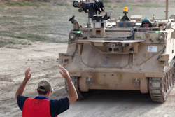 Workers prepare a modified Bradley Fighting Vehicle, known as a Mission Enabling Technologies-Demonstrator, during an exercise at Fort Carson, Colo.